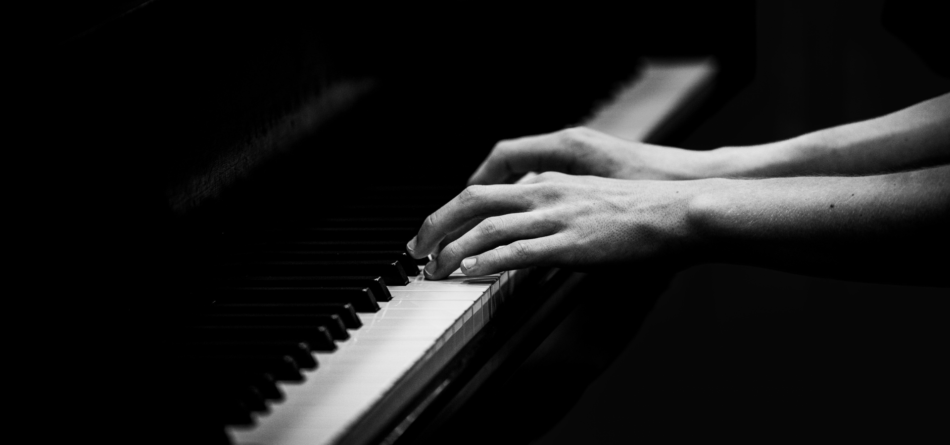 a black and white closeup of someone playing a steinway piano