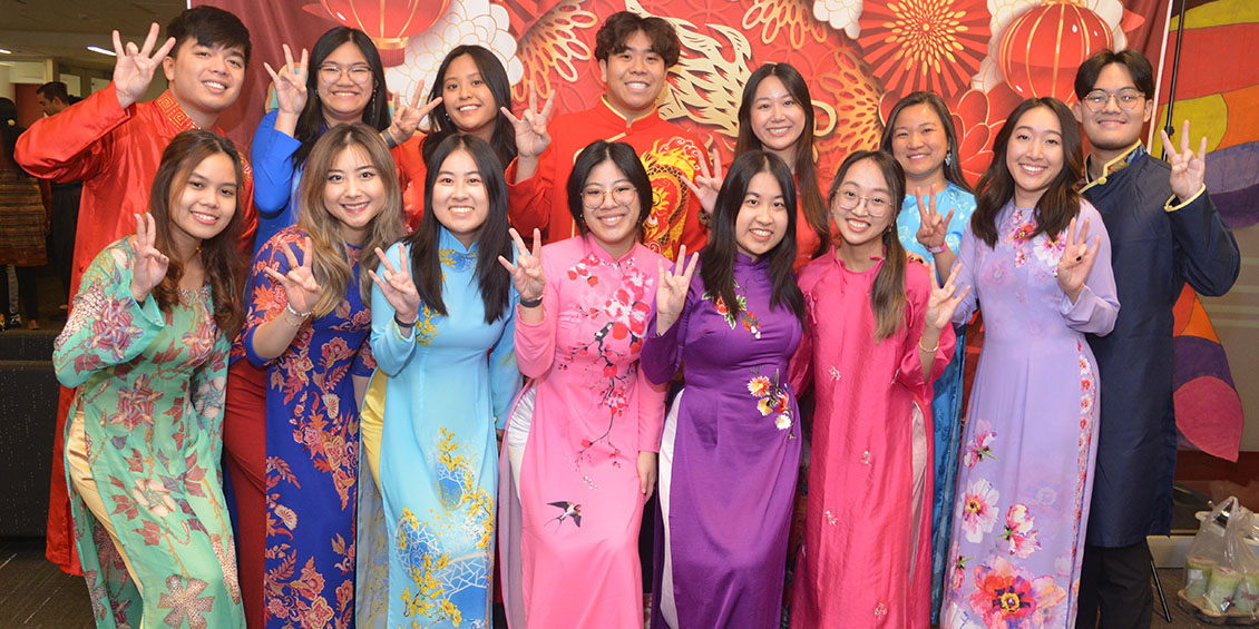 Group of students doing the Coog hand symbol.