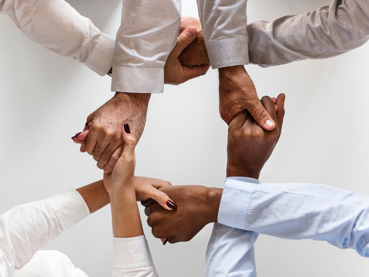 Pexels stock image of diverse hands clasping illustrating collaboration