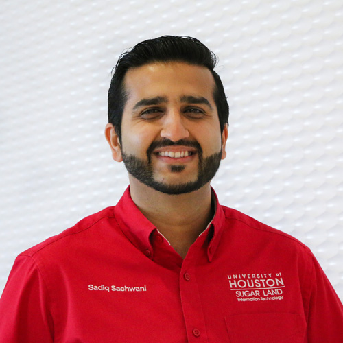 Portrait of an South Asian man smiling with a Hollywoodian beard wearing a red button-up shirt