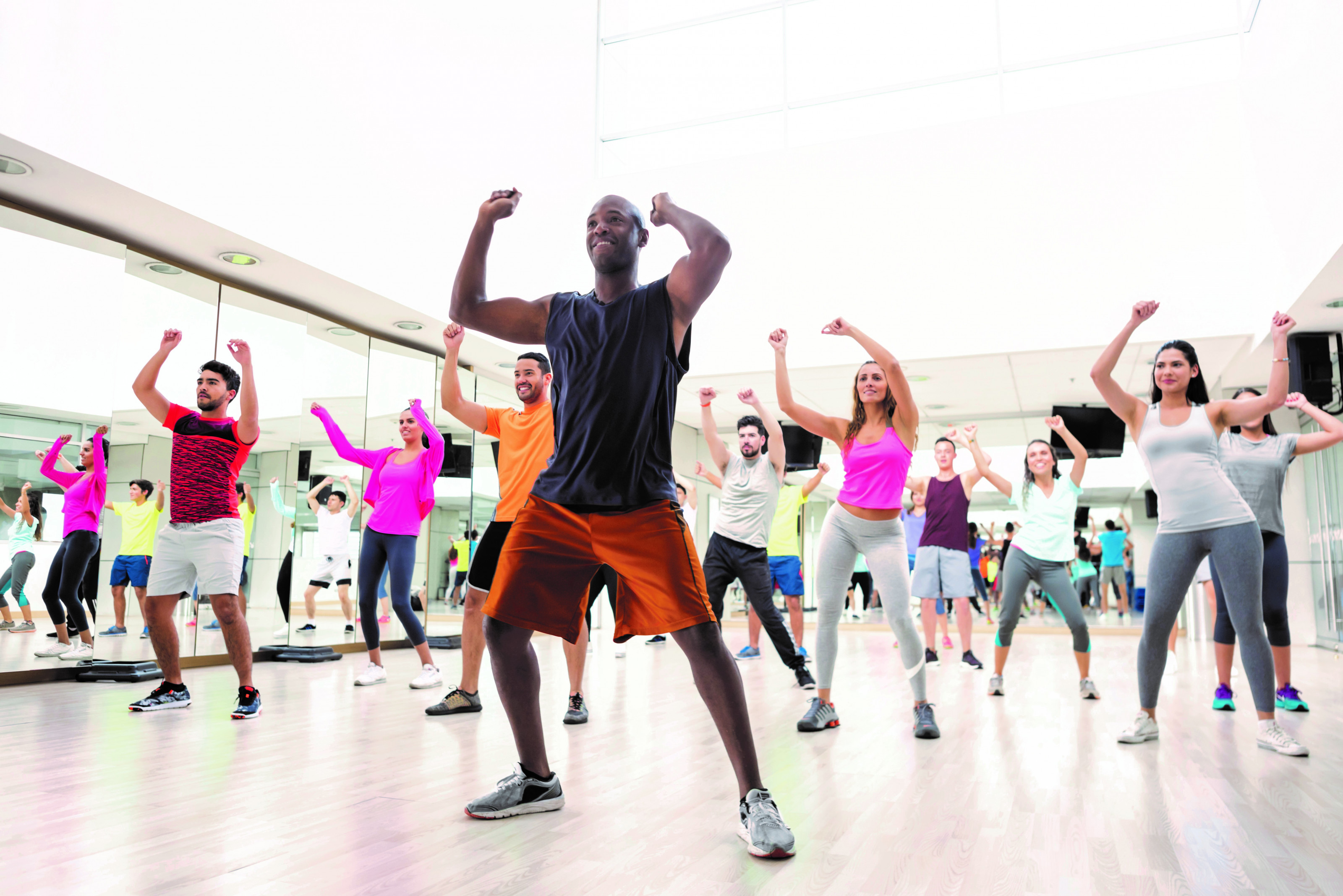 Diverse group of people at a rumba lesson in the gym all looking very happy and smiling