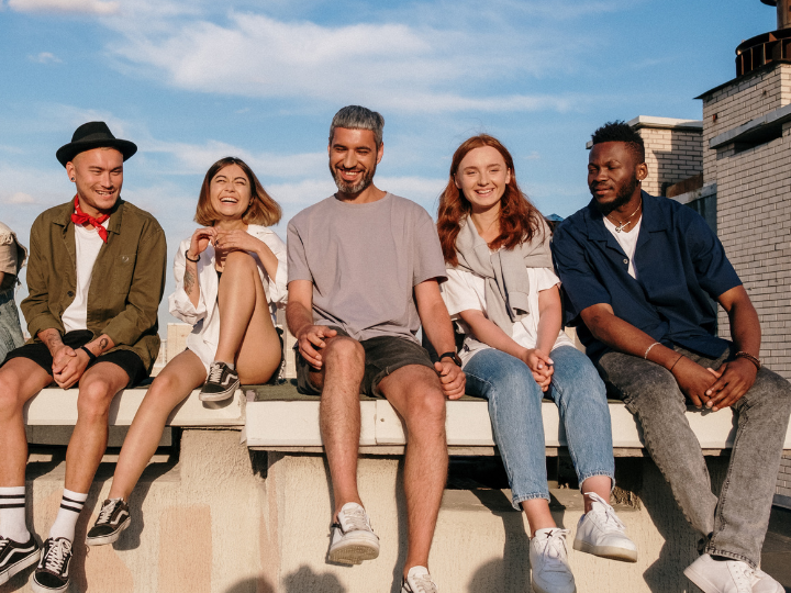Group of 5 students sitting on a ledge