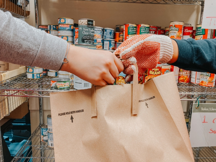 two hands holding a grocery bag