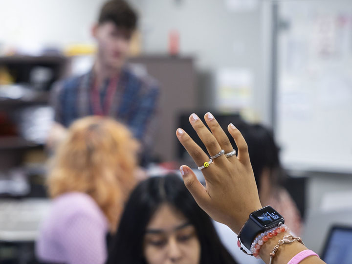 Student raising their hand in class