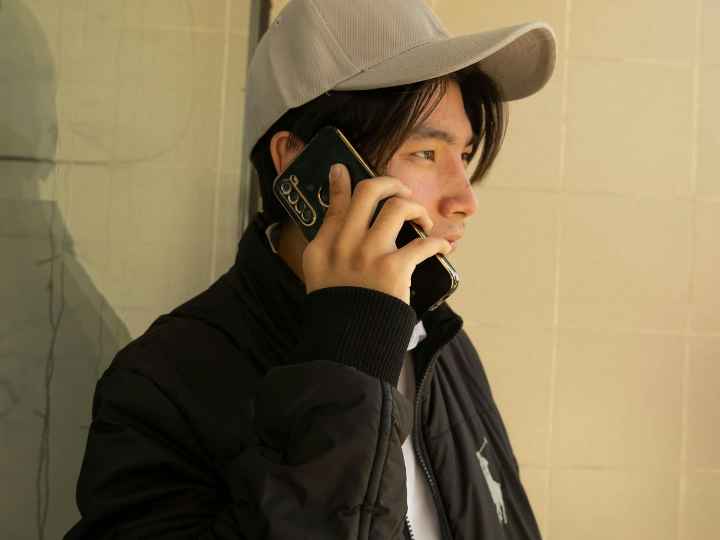 Man with a hat talking on a cell phone
