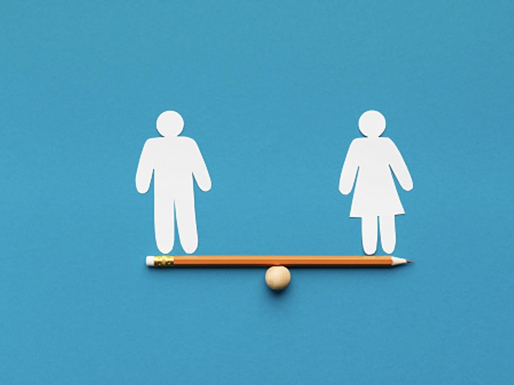 A male and female figures on top of a pencil balance