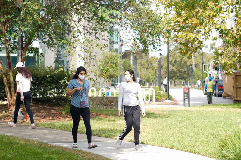 students walking on campus wearing masks
