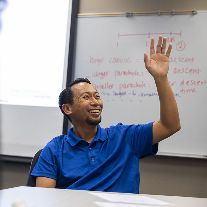 Male student raising his hand in the classroom