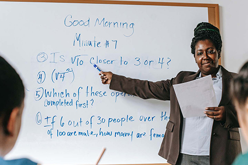Black female teacher at a whiteboard