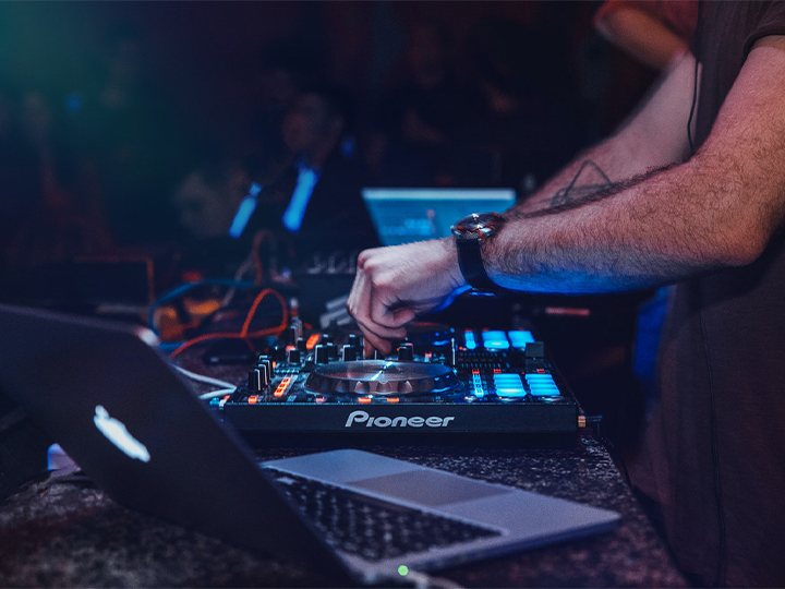 Person using a dj set up with laptop next to the set