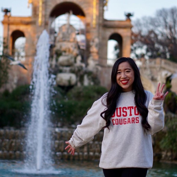 Student abroad giving the Coogs hand sign