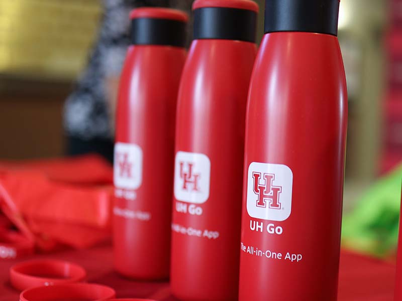 Close up of red reusable bottles with the UH logo.