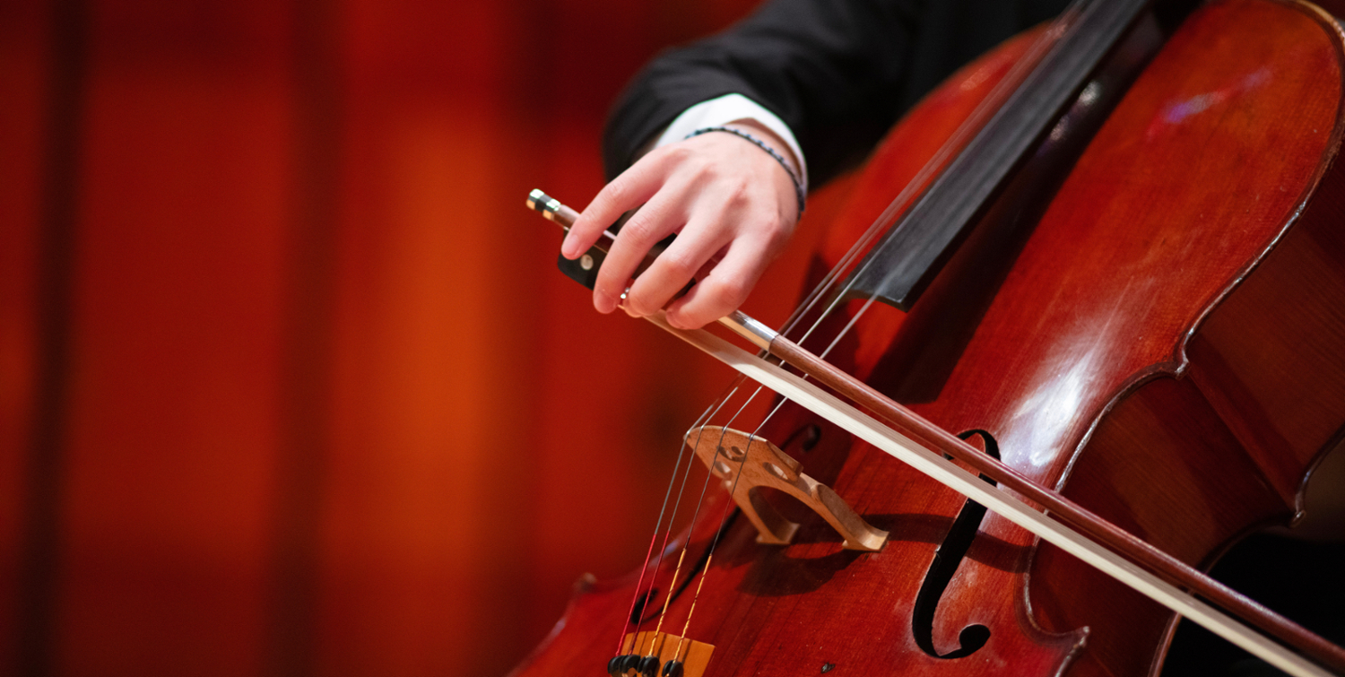 a close up shot of a man playing cello