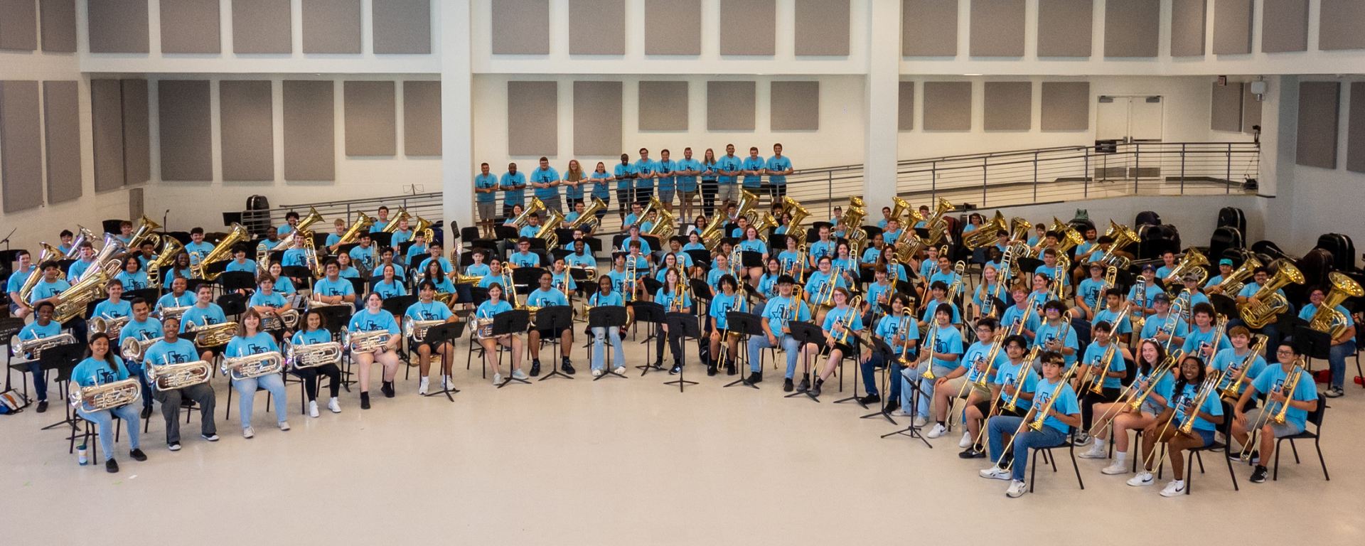 The 2023 Texas Low Brass Academy faculty and participants posing for a group photo in matching blue shirts