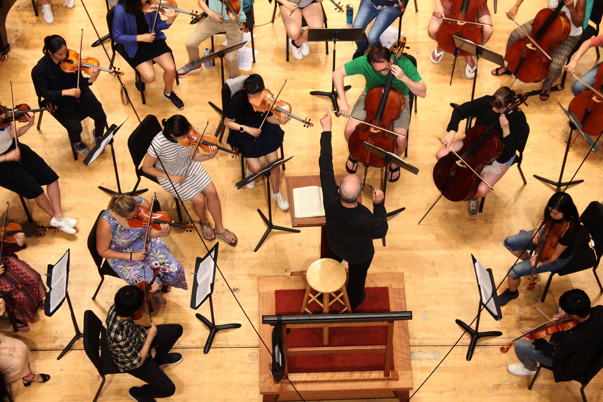looking down from above at an orchestra rehearsal, conducted by Hans Graf