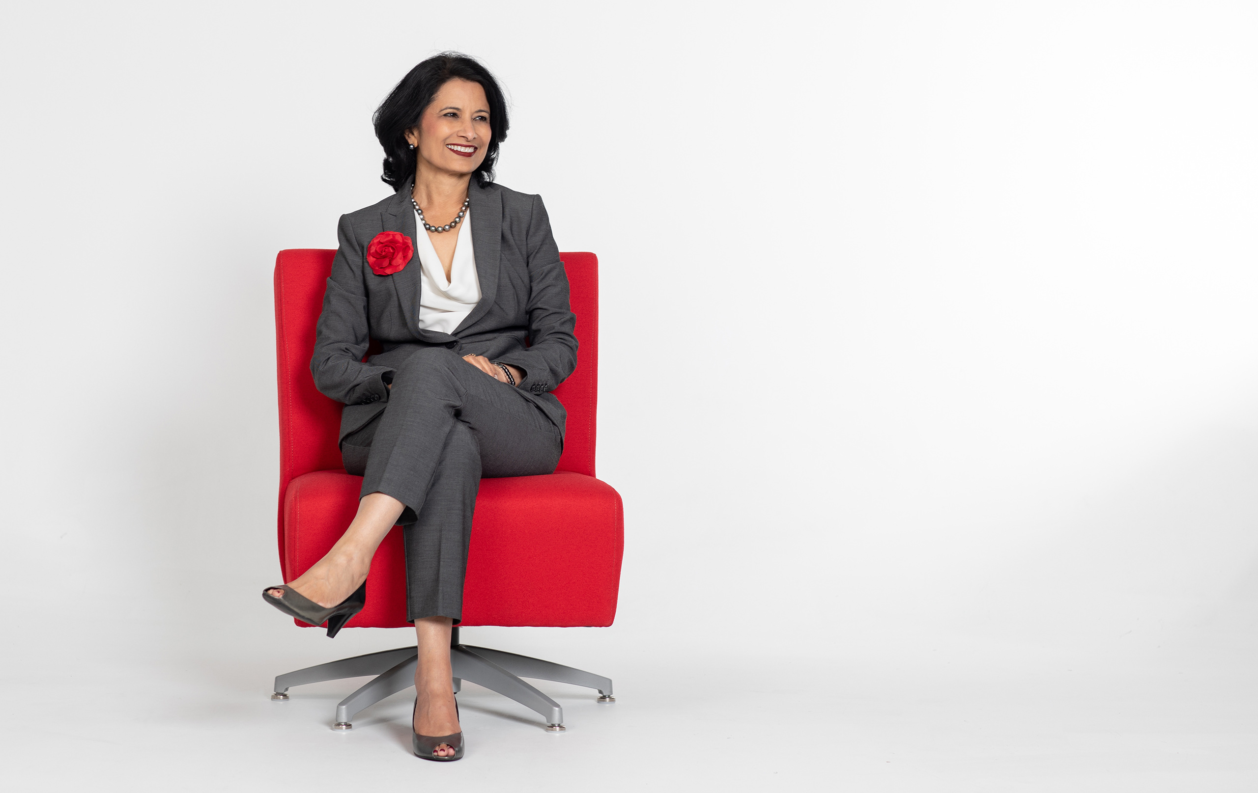 President Renu Khator sitting in a red chair