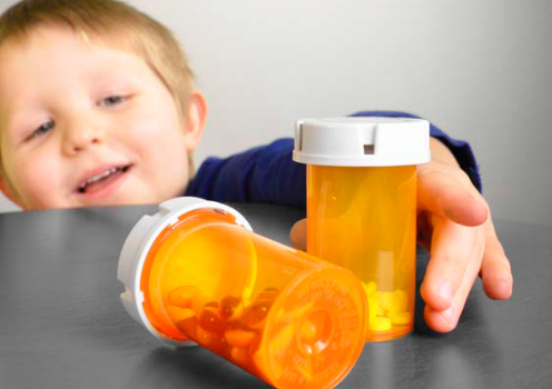 Child reaching for prescription bottles