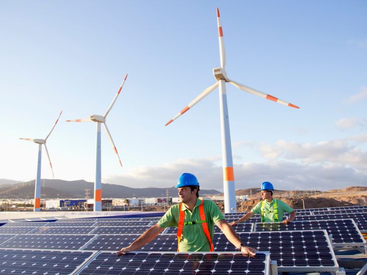Worker with solar panels and wind turbines