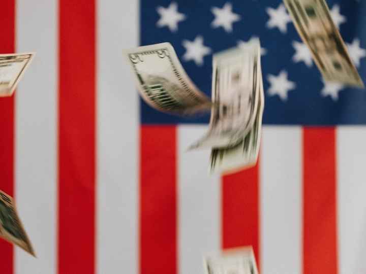 Photo showing dollars falling in front of American flag