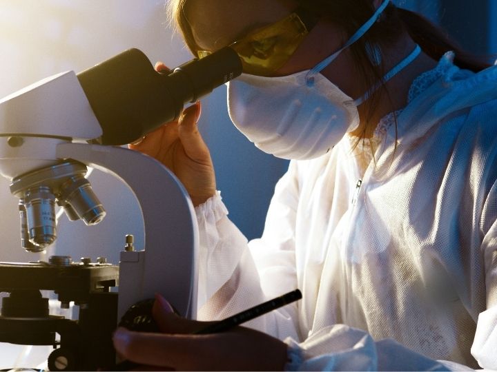 Photo of a scientist looking into a microscope