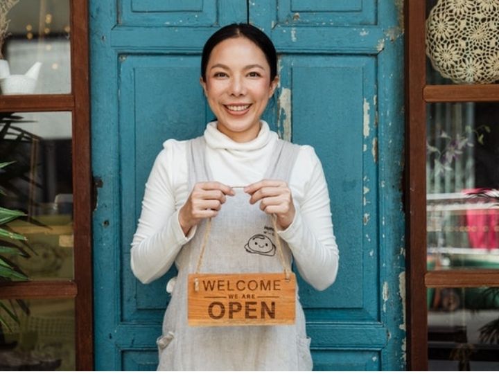 Woman store owner welcoming customers