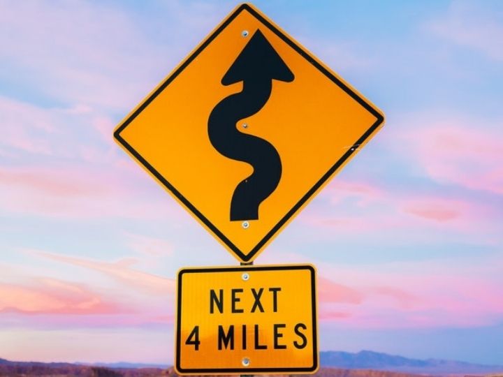 Photo of road sign that warns of curves ahead