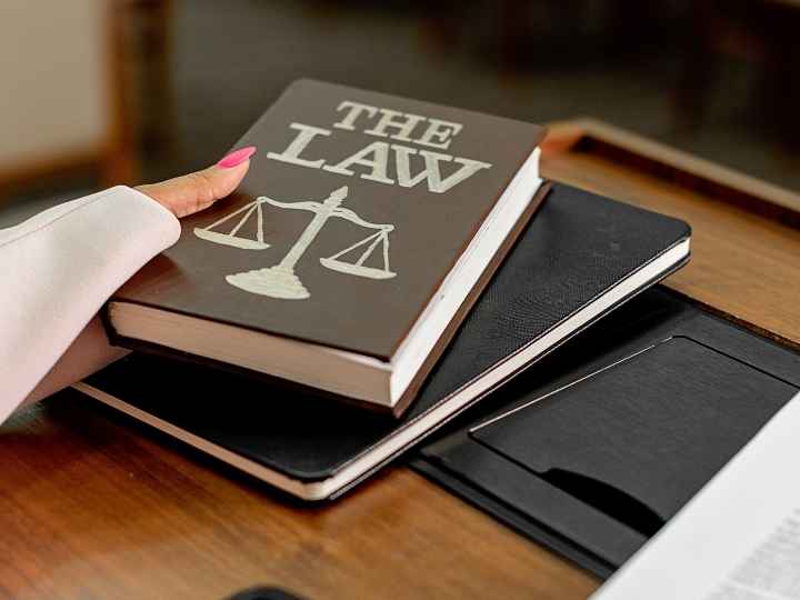 Photo of woman’s hand holding a law book
