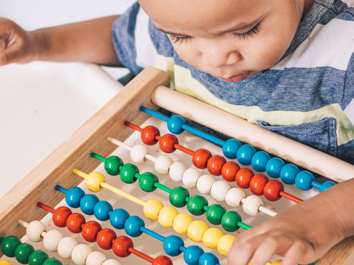 Child moving beads on abacus