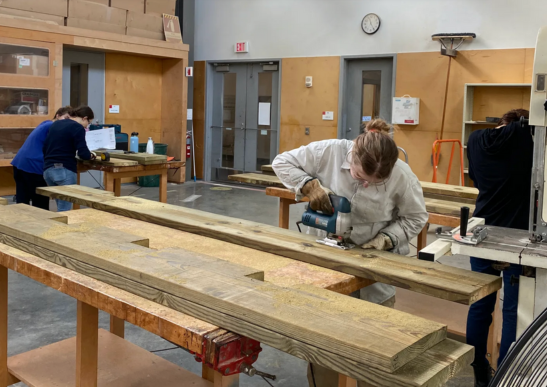 Image of graduate students in a woodwork shop.
