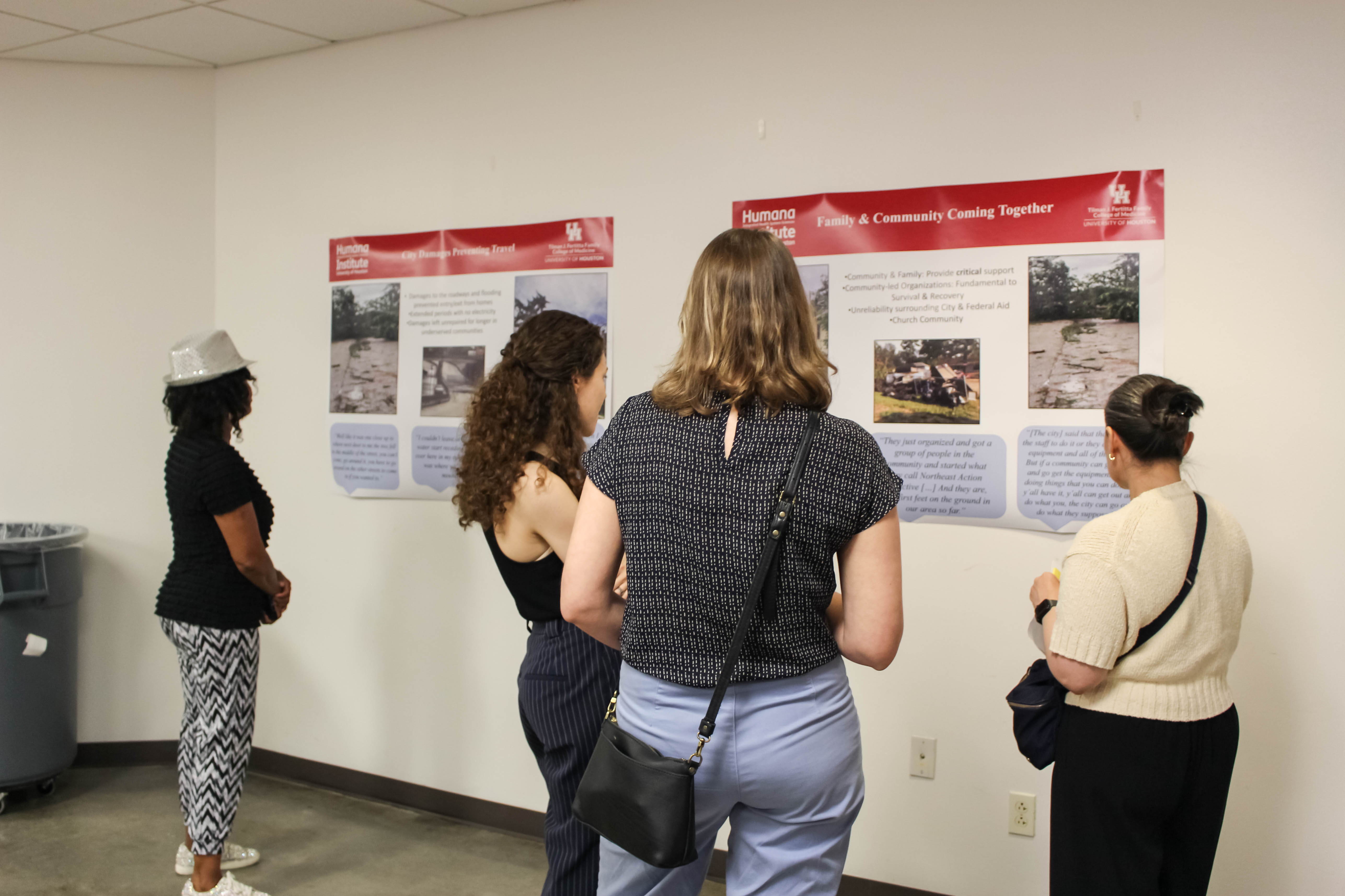 people looking at flood victim's story posters