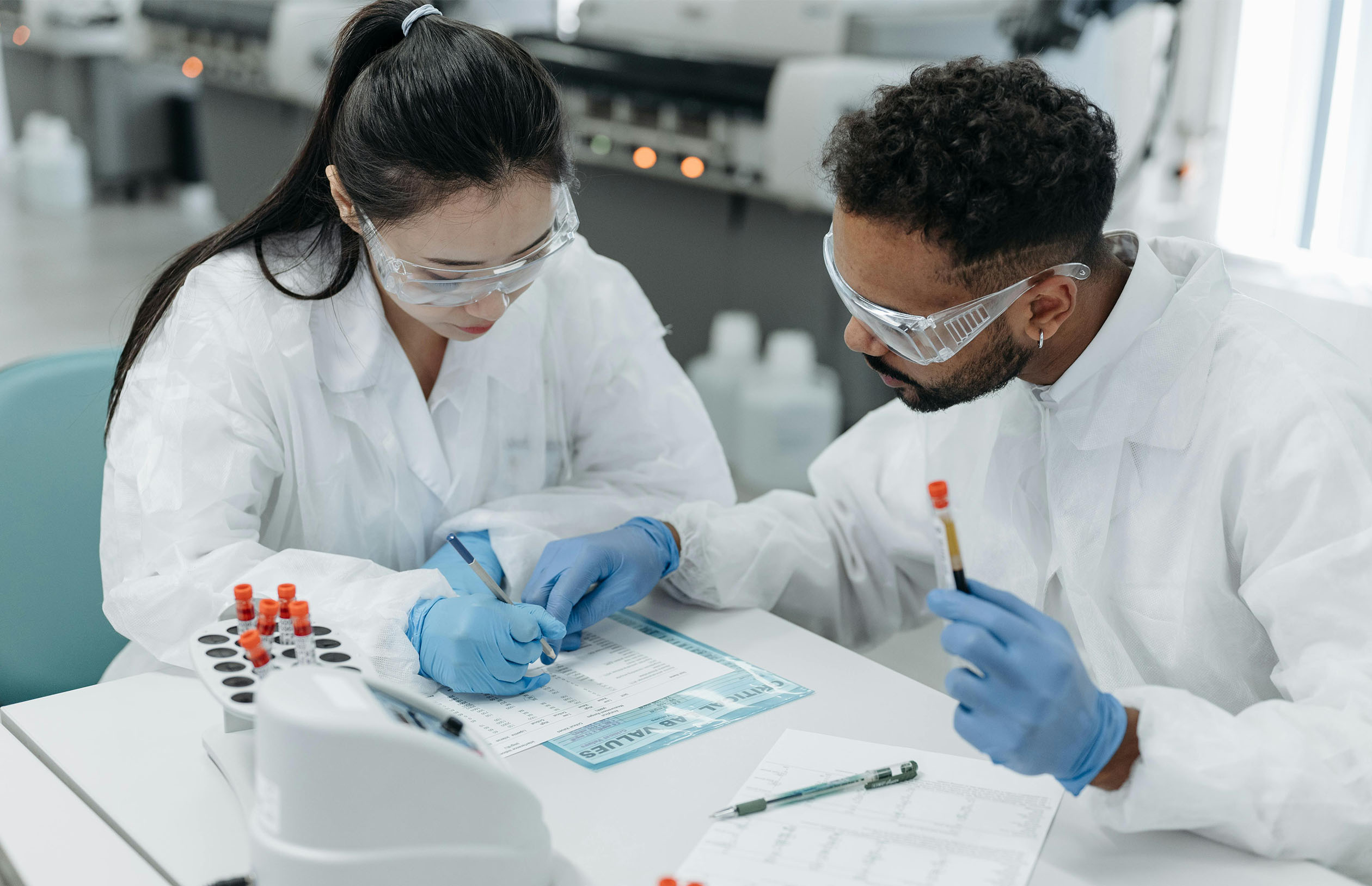Researchers wearing lab coats while looking at documents.
