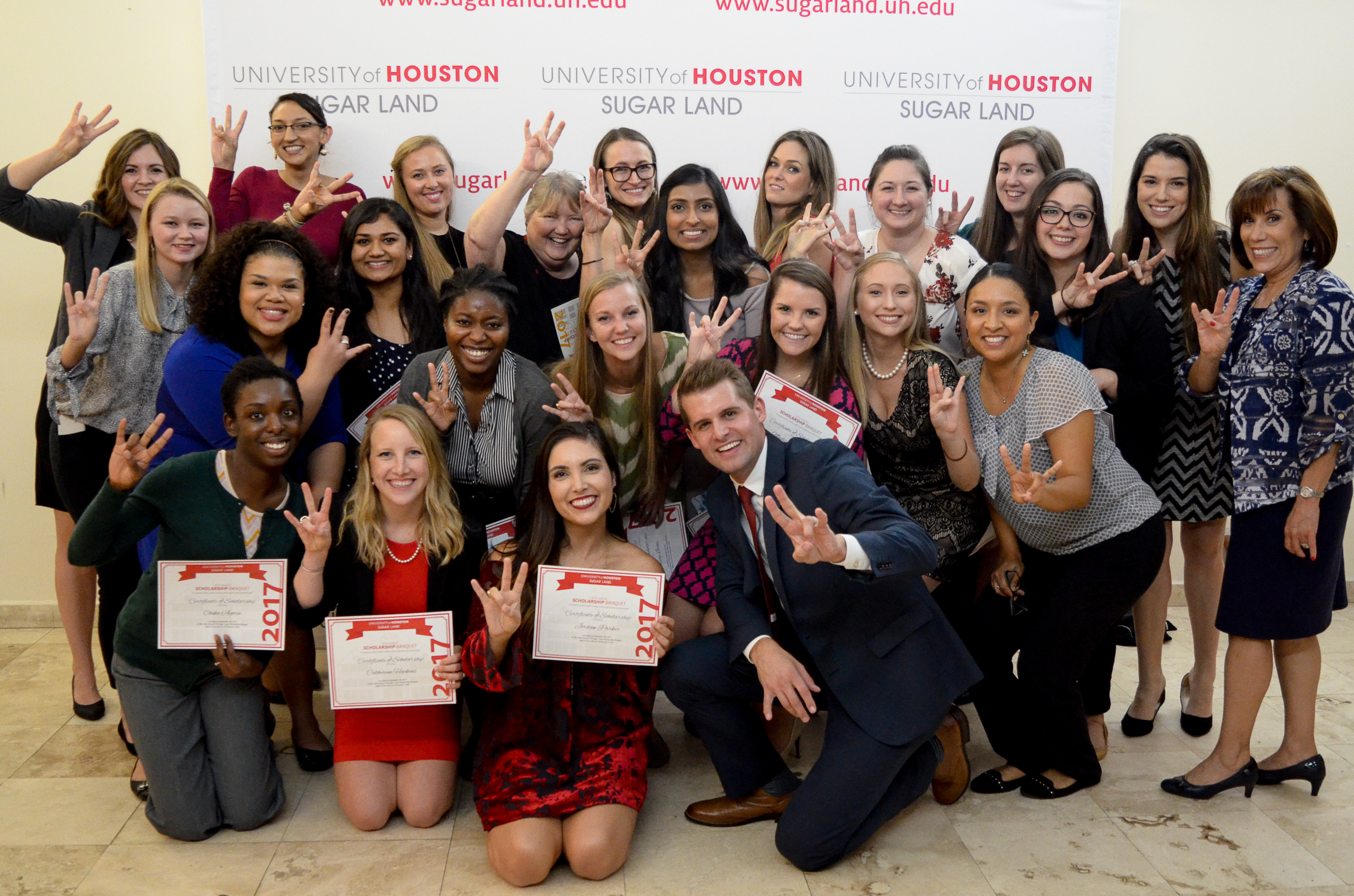 Group of students making Go coogs handsign