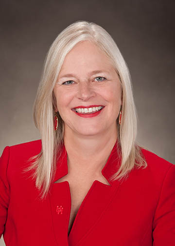 Portrait of a blonde woman wearing a red business jacket