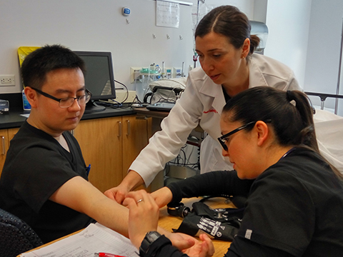 Nursing professor and students checking blood pressure