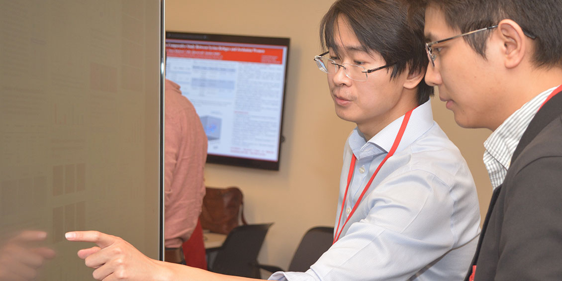 poster presenter discusses project with attendee