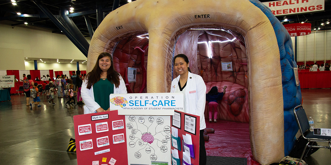Students educate festival attendees about self care and mental health outside an inflatable brain.