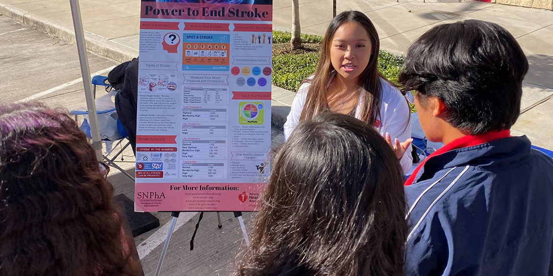 student discusses stroke with event attendees