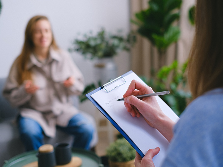 patient receiving health consultation from health professional who is taking notes