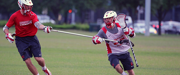 Two students playing lacrosse