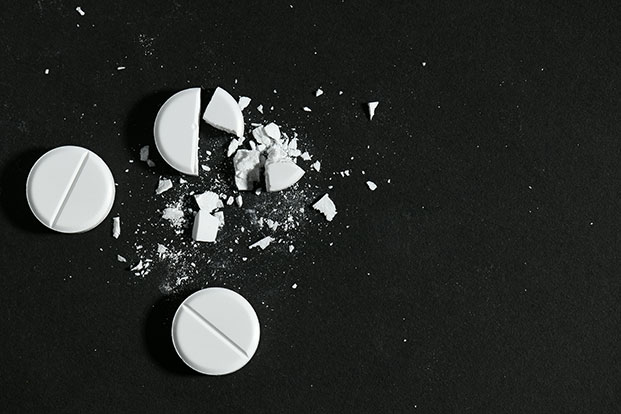 White pills on black background.