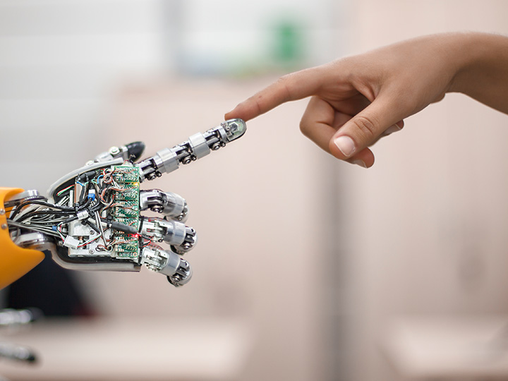 Robot and human hands touching fingertips