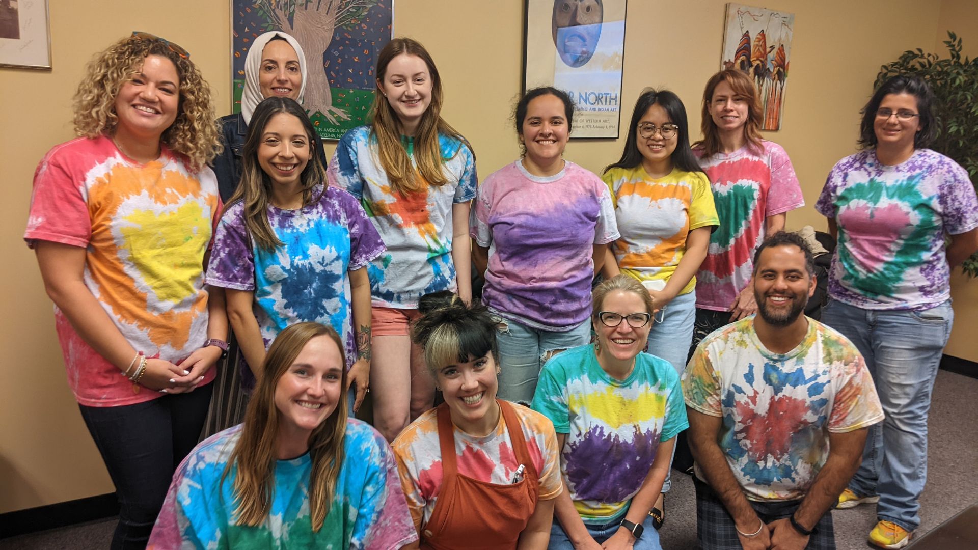 Group photo of MSW and PHD students who participated in the Dive Into Action Reseach Training. They are all wearing tie-dyed shirts.