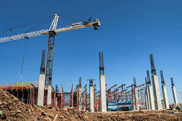A tall crane over concrete pillars at a construction site