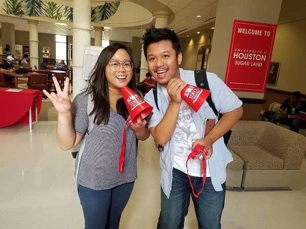 A female and male student holding red megaphones