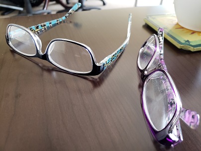 Two pairs of glasses on a brown table