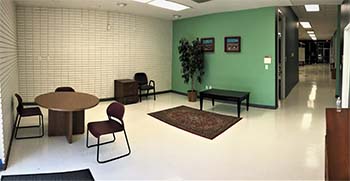 Photograph of the clinic's interior. A waiting area has seating and is connected to a hallway that leads further into the facilities.