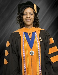 Portrait of a woman wearing orange and black graduation regalia