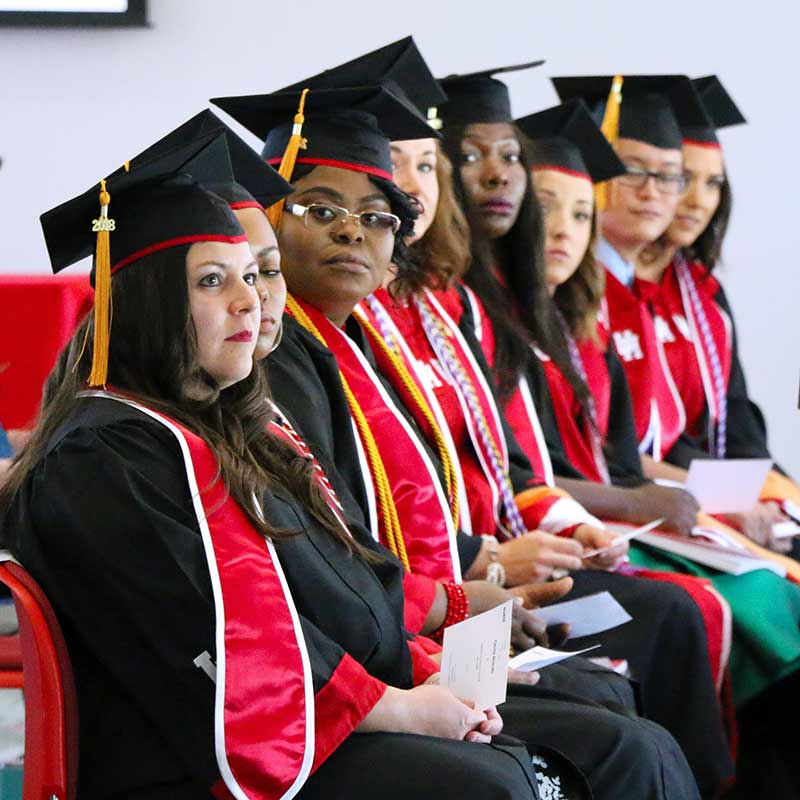 A group of graduates in regalia seated in a row