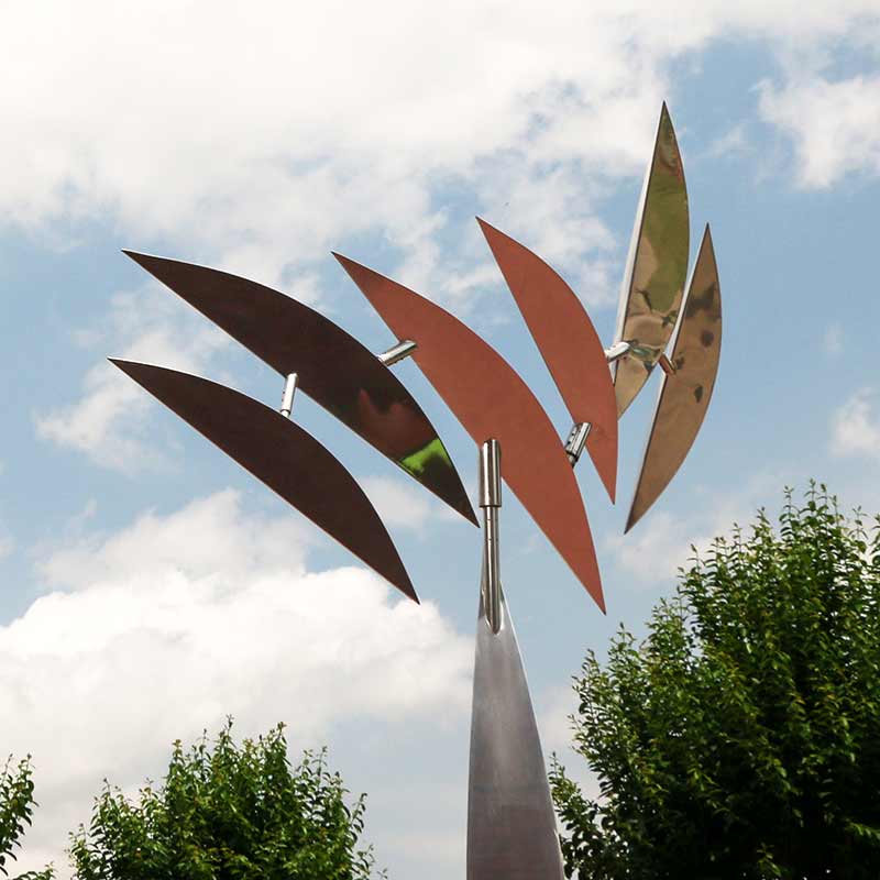 A metallic moving sculpture shaped like a palm tree