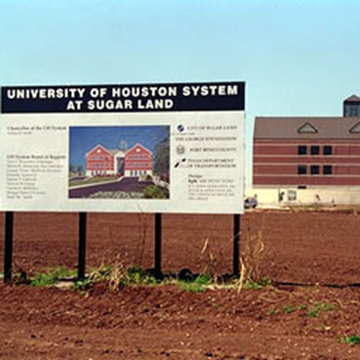 Construction sign in the foreground with a bulding in the background